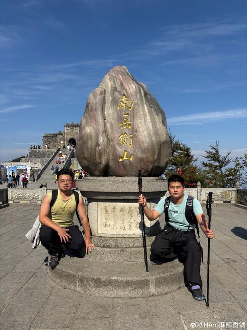 男子攀爬五岳独尊石,游客爬上五岳独尊石刻拍照